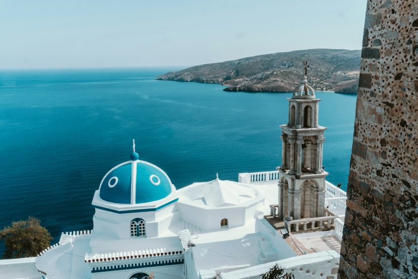 a white building with a blue ocean in the background Astypalea Greece