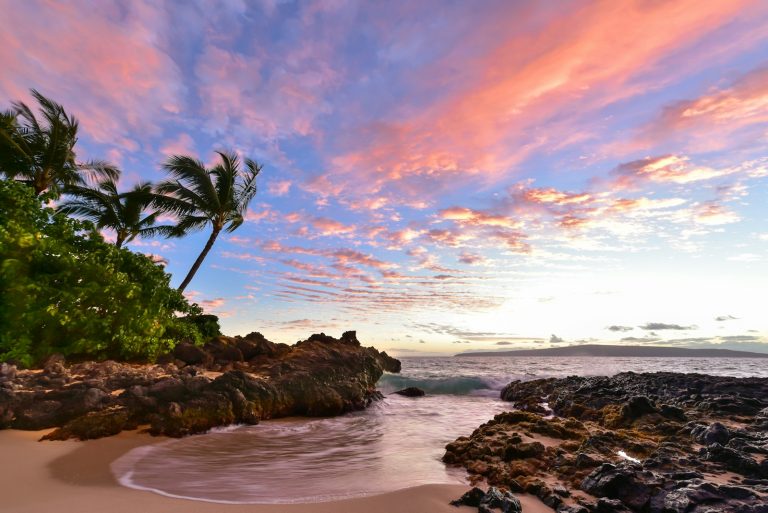 a beach that has some rocks in it in Maui, Hawaii