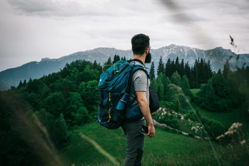 A male hiker explores lush Romanian mountain scenery, embodying adventure and exploration.