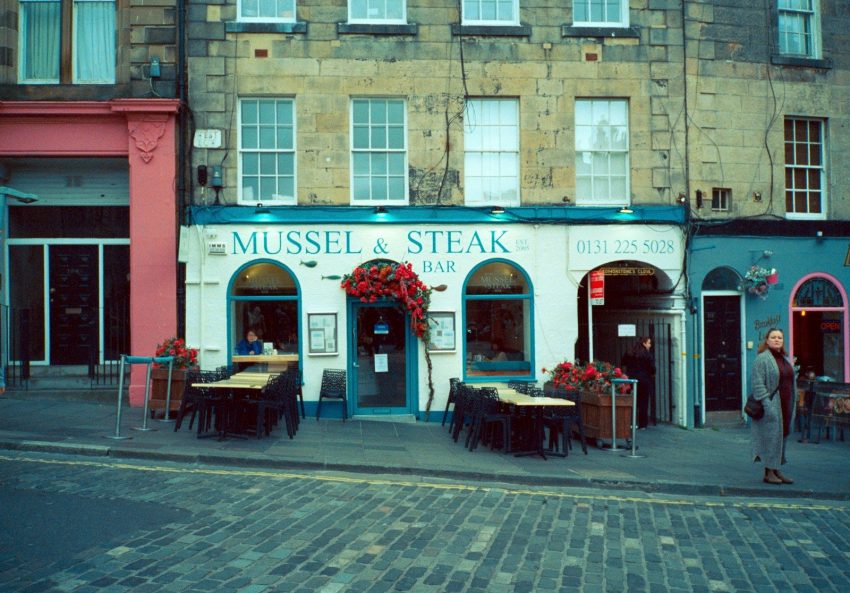 Mussel & steak bar restaurant facade with outdoor seating.