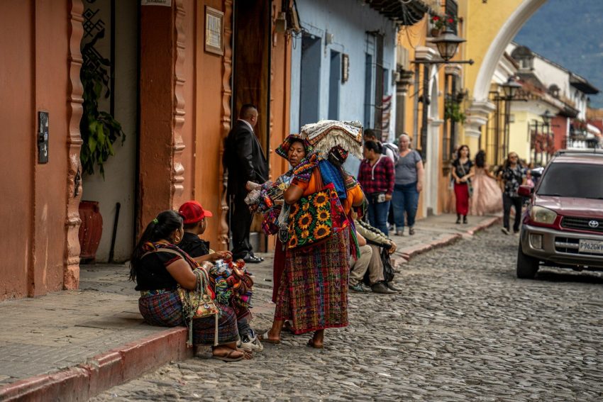 a group of people sitting on the sidewalk in Guatemala