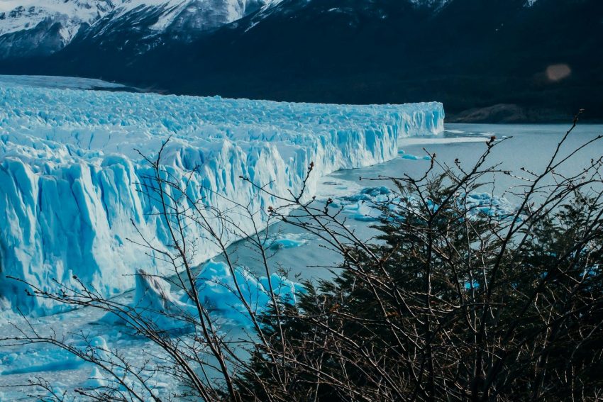 a large glacier with snow capped mountains in the background, El Calafate, Argentina