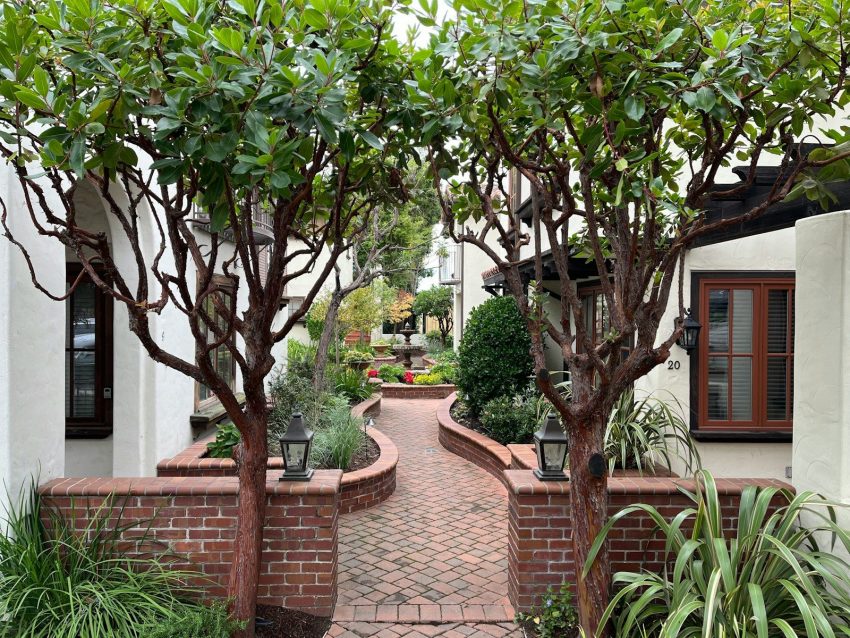 a brick walkway between two white buildings, Carmel-by-the-Sea, California