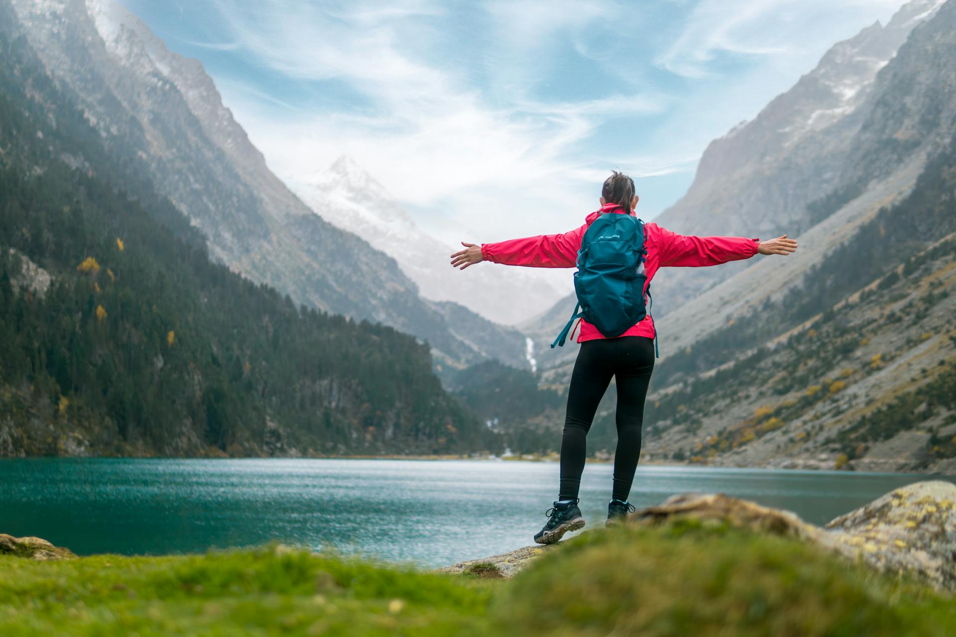 A hiker in the mountains with a backpack looking at the view.