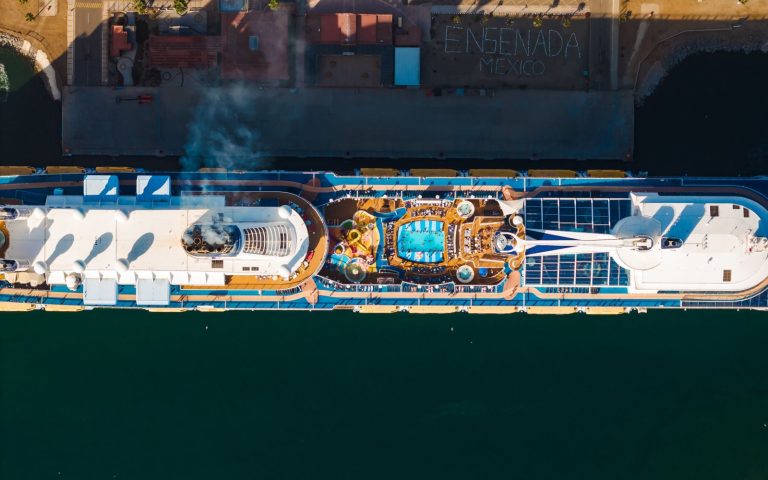 Stunning aerial shot of a cruise ship docked at Ensenada, Mexico, showcasing its pool deck.