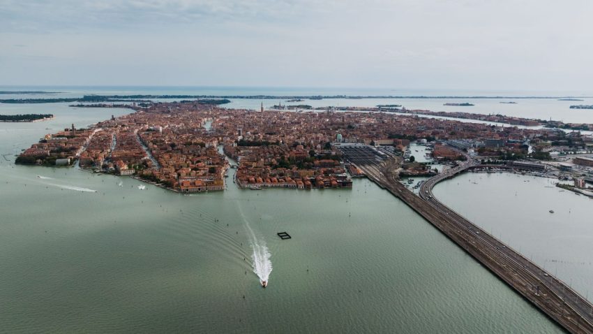 Stunning aerial view of Venice showcasing its canals and iconic architecture. Serene turquoise waters add beauty.