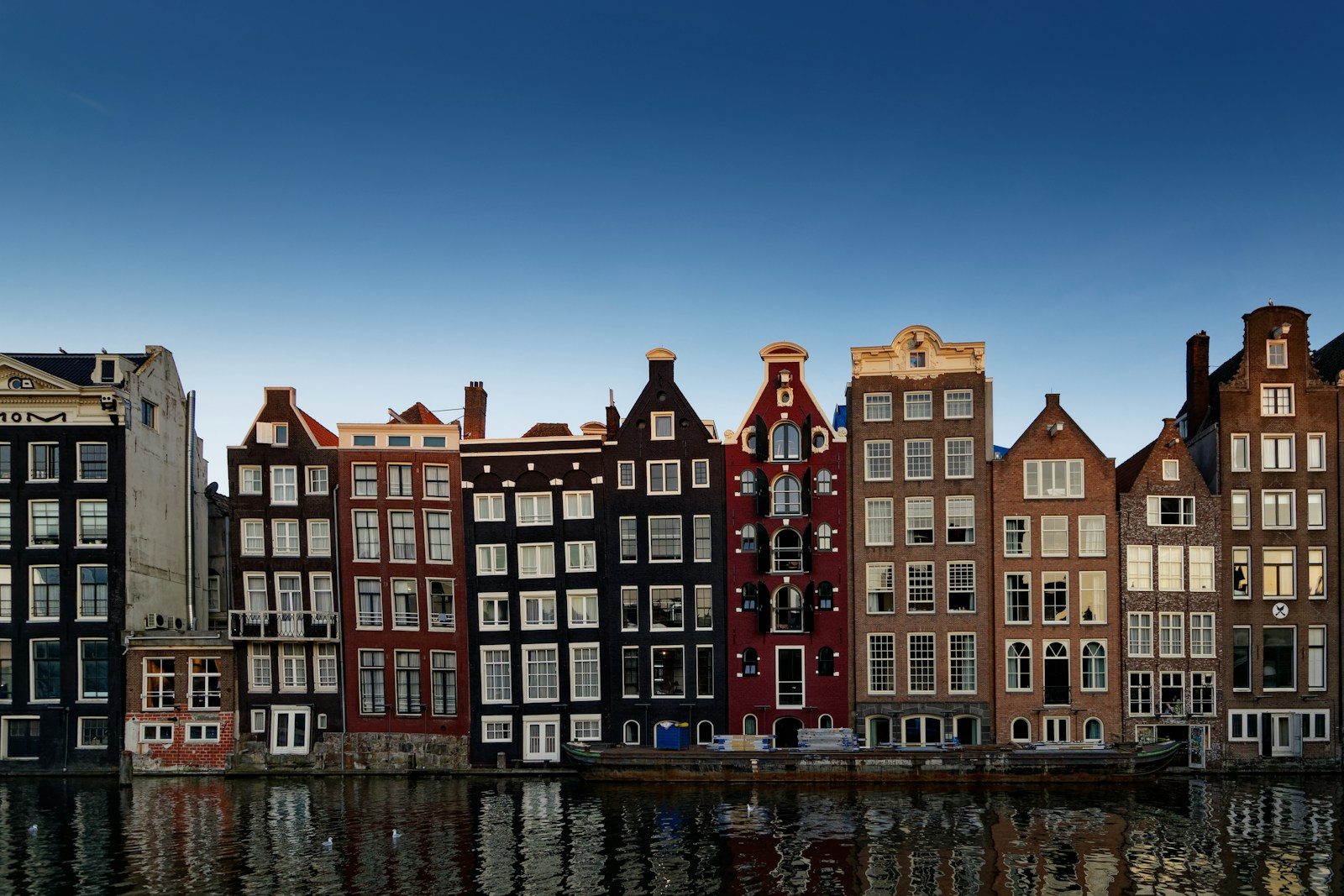 red and white concrete building beside body of water during daytime, Amsterdam, Netherlands, Holland